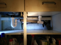 Small air admittance valve installed beside sink