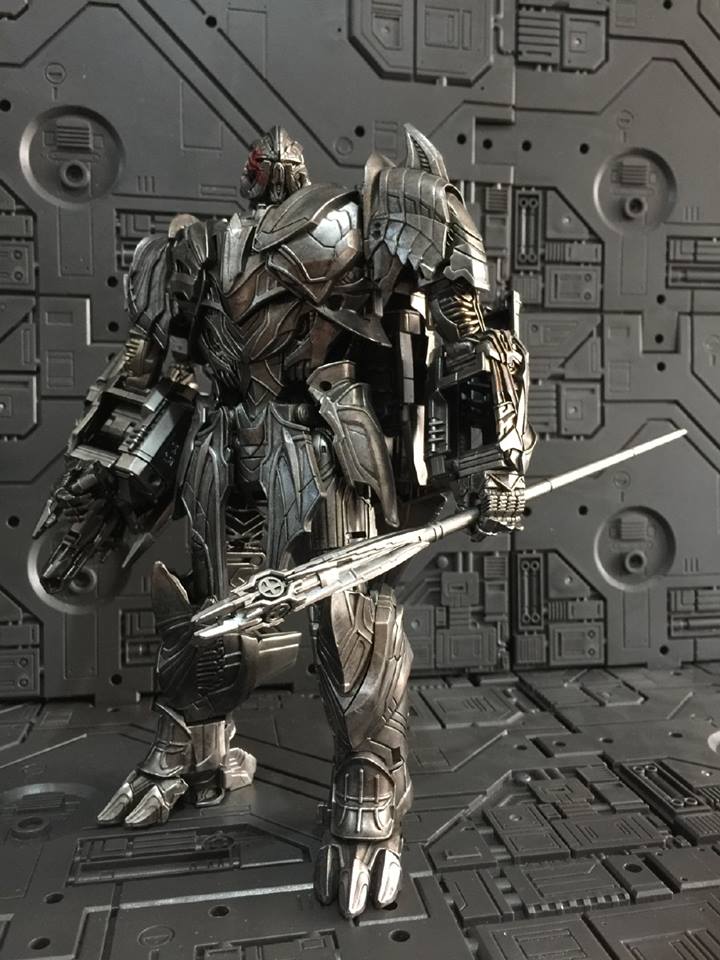 Silver armored robot figure holding large sword weapon in heroic pose Silver armored robot figure holding large sword weapon in heroic pose