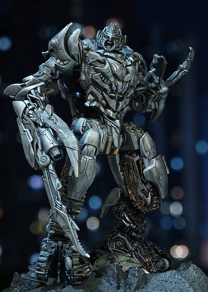 Silver and blue Megatron figure standing with weapon systems Silver and blue Megatron figure standing with weapon systems