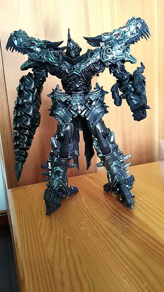 Dark scaled dinosaur-form robot with jagged spikes and fangs Dark scaled dinosaur-form robot with jagged spikes and fangs