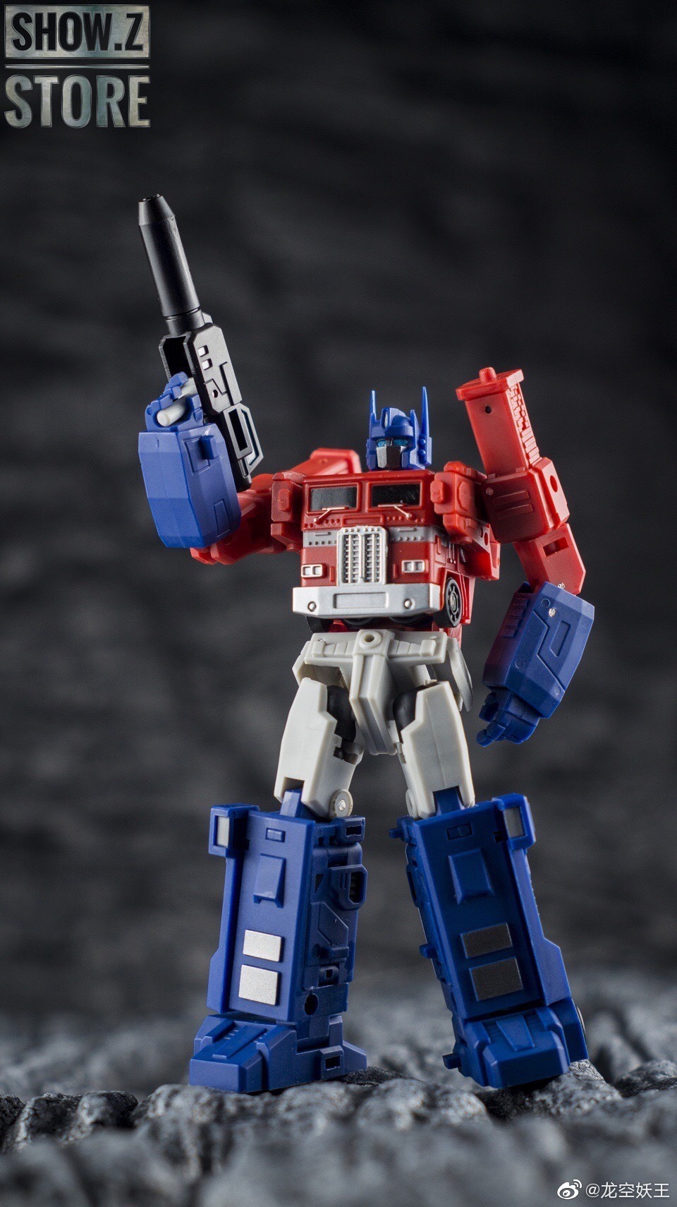 Red blue and white robot holding large weapon in stance Red blue and white robot holding large weapon in stance