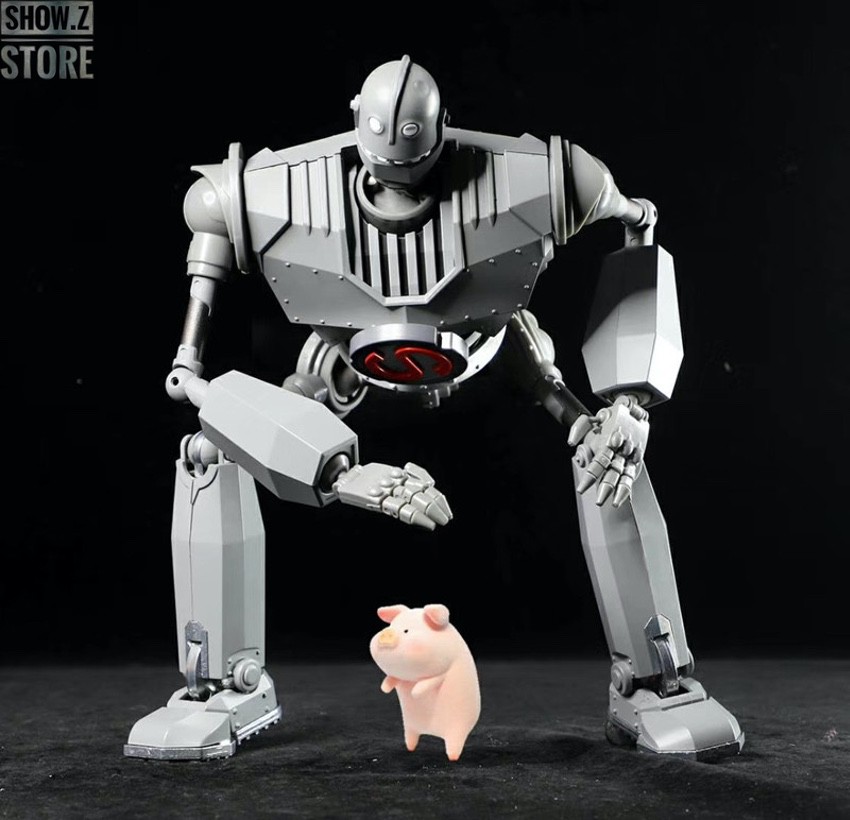 White retro robot figure towering over tiny pink pig toy White retro robot figure towering over tiny pink pig toy