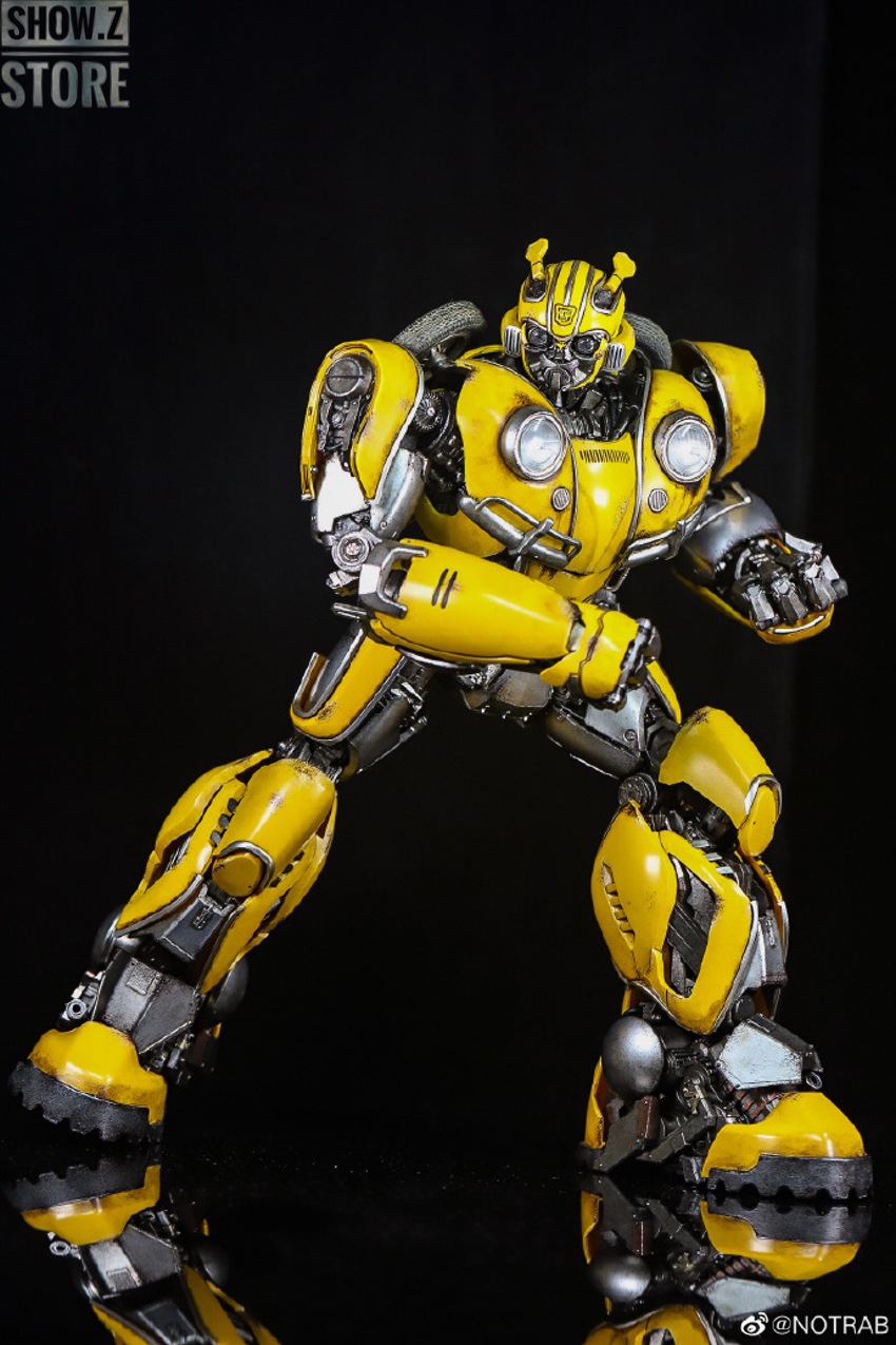Yellow and black robot standing with weapon in ready position Yellow and black robot standing with weapon in ready position
