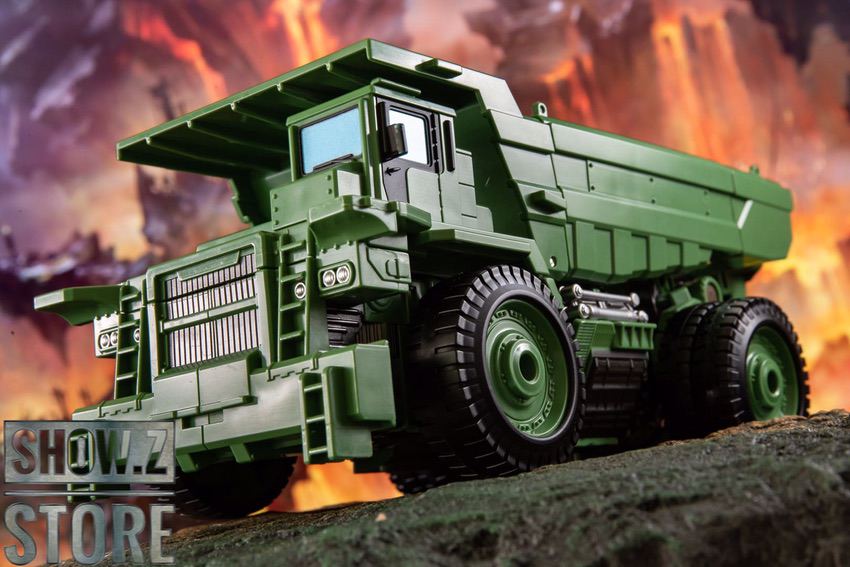 Green MT-03 truck mode with white cabin and large cargo bed on rocky terrain Green MT-03 truck mode with white cabin and large cargo bed on rocky terrain