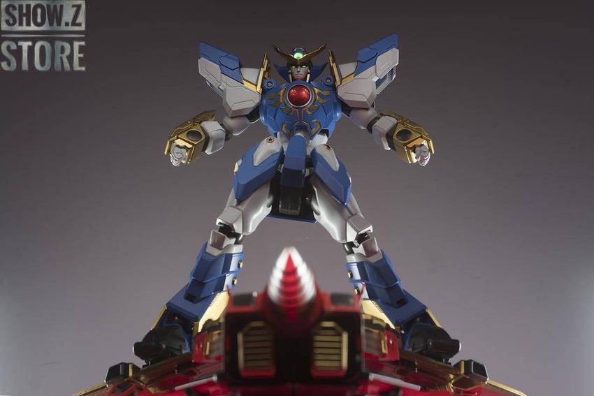 Blue white robot with horned head and golden weapon raised high Blue white robot with horned head and golden weapon raised high