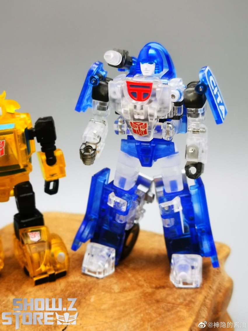 NewAge Shean Mirage clear version adjacent yellow robot compare NewAge Shean Mirage clear version adjacent yellow robot compare