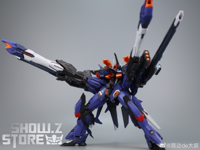 Blue Gundam suit standing with extended arms holding various firearms Blue Gundam suit standing with extended arms holding various firearms