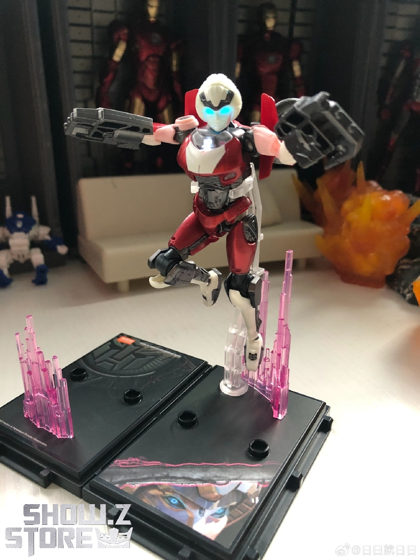 Red and white Transformer robot in dynamic action pose with extended weapon arm Red and white Transformer robot in dynamic action pose with extended weapon arm