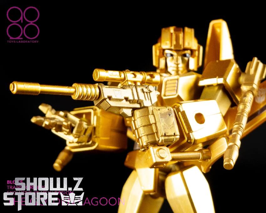 Golden armored robot figure posing with extended cannon weapon in combat position Golden armored robot figure posing with extended cannon weapon in combat position