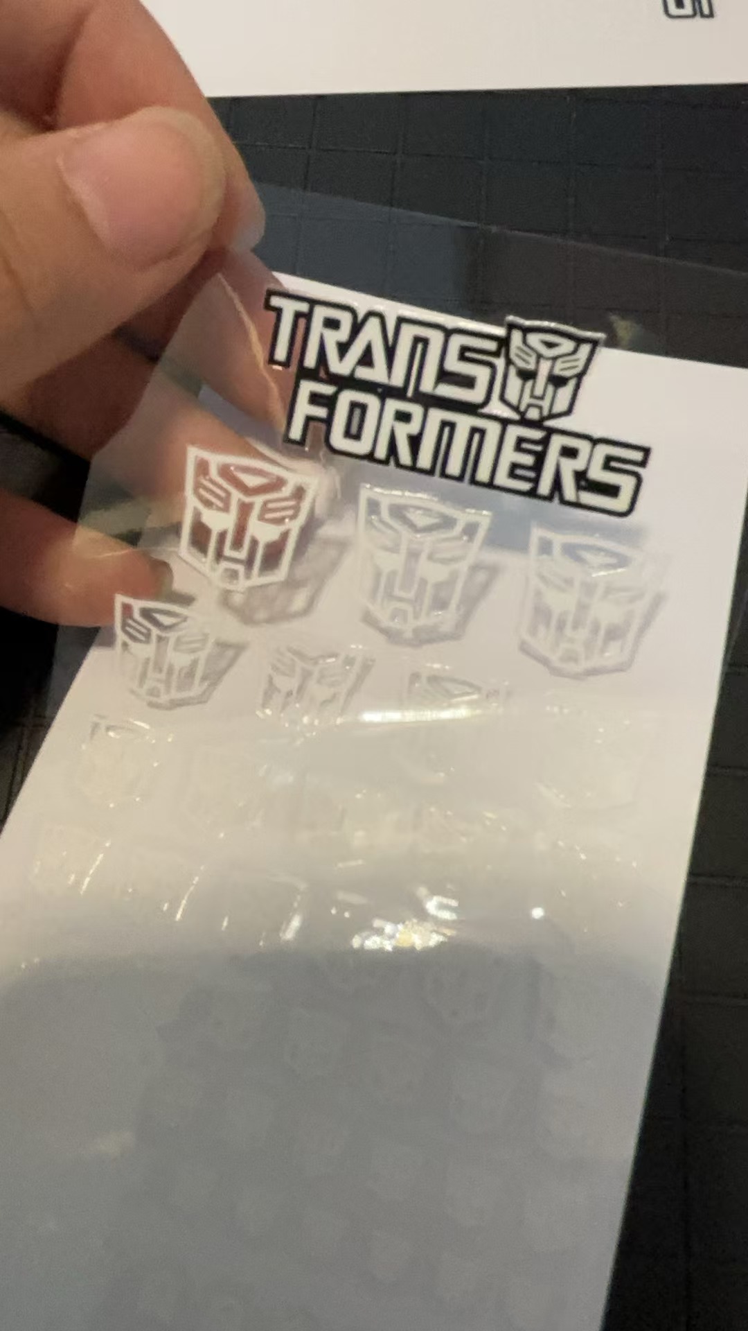 Clear sticker sheet showing Transformers faction symbol variations applied Clear sticker sheet showing Transformers faction symbol variations applied