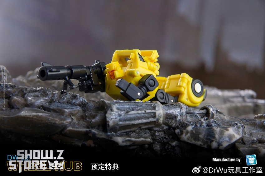 Yellow black robot showcasing weapon attachment on log Yellow black robot showcasing weapon attachment on log
