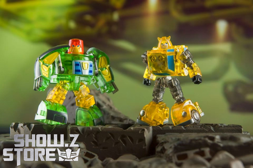 Green and yellow transparent transformer toys standing together on rock Green and yellow transparent transformer toys standing together on rock