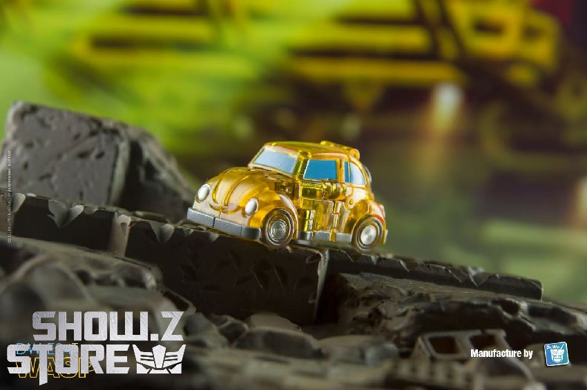 Tiny golden yellow miniature car figure on dark rocky surface Tiny golden yellow miniature car figure on dark rocky surface