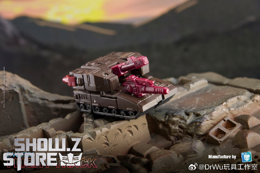 Maroon and pink drill vehicle positioned on rocky terrain with mountains landscape Maroon and pink drill vehicle positioned on rocky terrain with mountains landscape