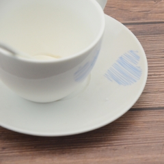 White porcelain coffee cup with base and spoon