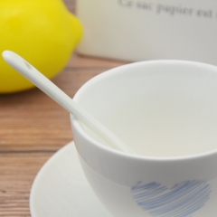 White porcelain coffee cup with base and spoon
