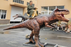 Paseo en dinosaurio para niños en el parque de atracciones
