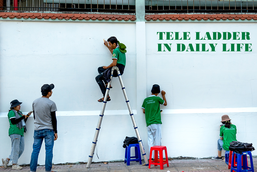 La gente está discutiendo cómo pintar un mural y un hombre está sentado en una escalera telescópica contando su plan.