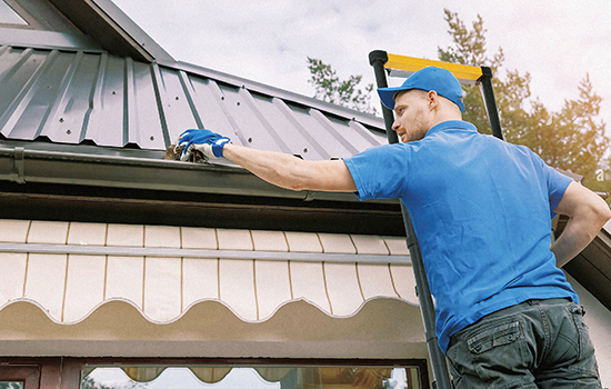 tradesman is repairing the roof of house with telescoping ladder