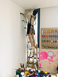 a girl is climbing a telescopic ladder to fixing the curtain