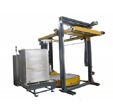 conveyorized turntable pallet wrapper with top sheet dispenser