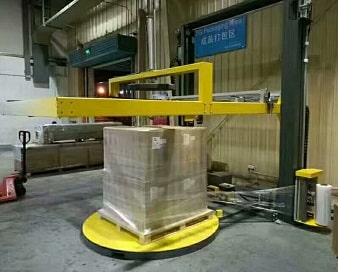 turntable pallet wrapper with top film dispenser