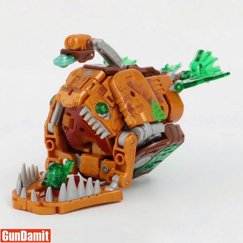 52Toys BeastBox BB-42 Rustypiece in dinosaur beast mode three-quarter view showing orange body and green crystal details 52Toys BeastBox BB-42 Rustypiece in dinosaur beast mode three-quarter view showing orange body and green crystal details