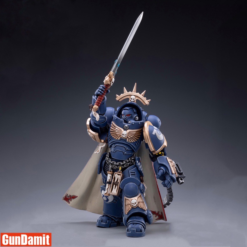 JoyToy 1/18 Ultramarines Primaris Captain Voltian front view raising power sword with flowing cape and iron halo crown JoyToy 1/18 Ultramarines Primaris Captain Voltian front view raising power sword with flowing cape and iron halo crown
