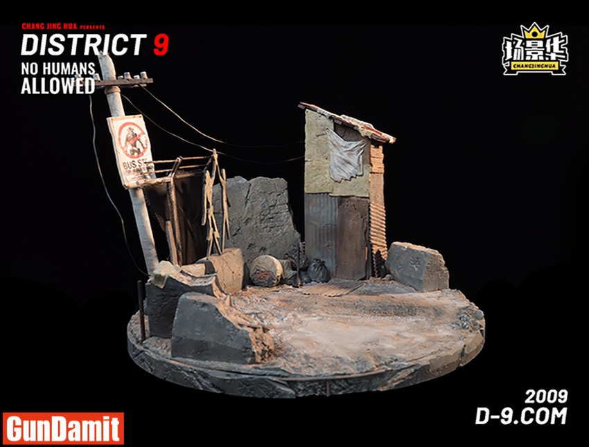Side view of District 9 diorama showing mecha posed alongside corrugated shacks and bus stop Side view of District 9 diorama showing mecha posed alongside corrugated shacks and bus stop
