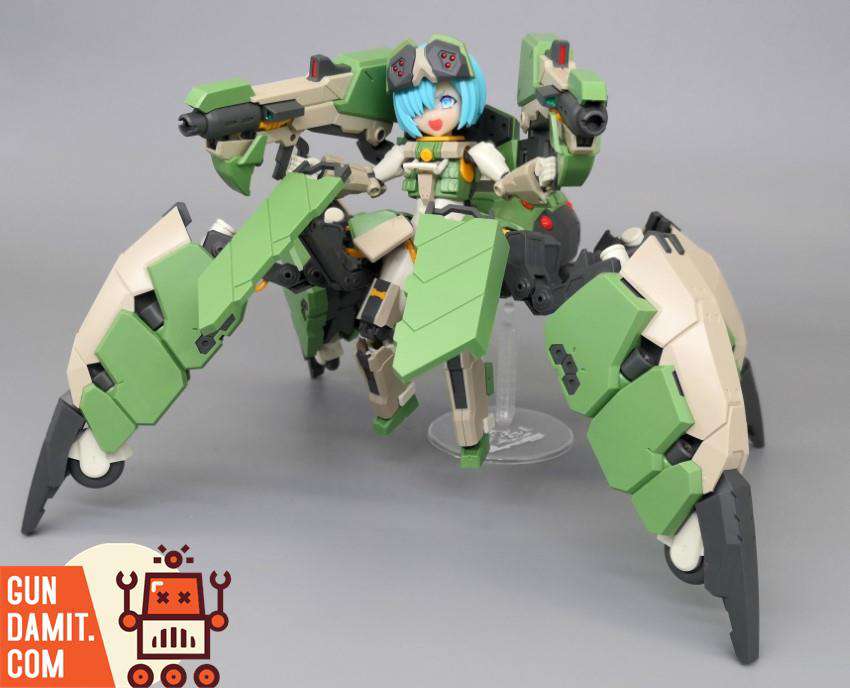 Feidy figure standing in spider mech frame with blue hair and raised weapon arms on display stand Feidy figure standing in spider mech frame with blue hair and raised weapon arms on display stand