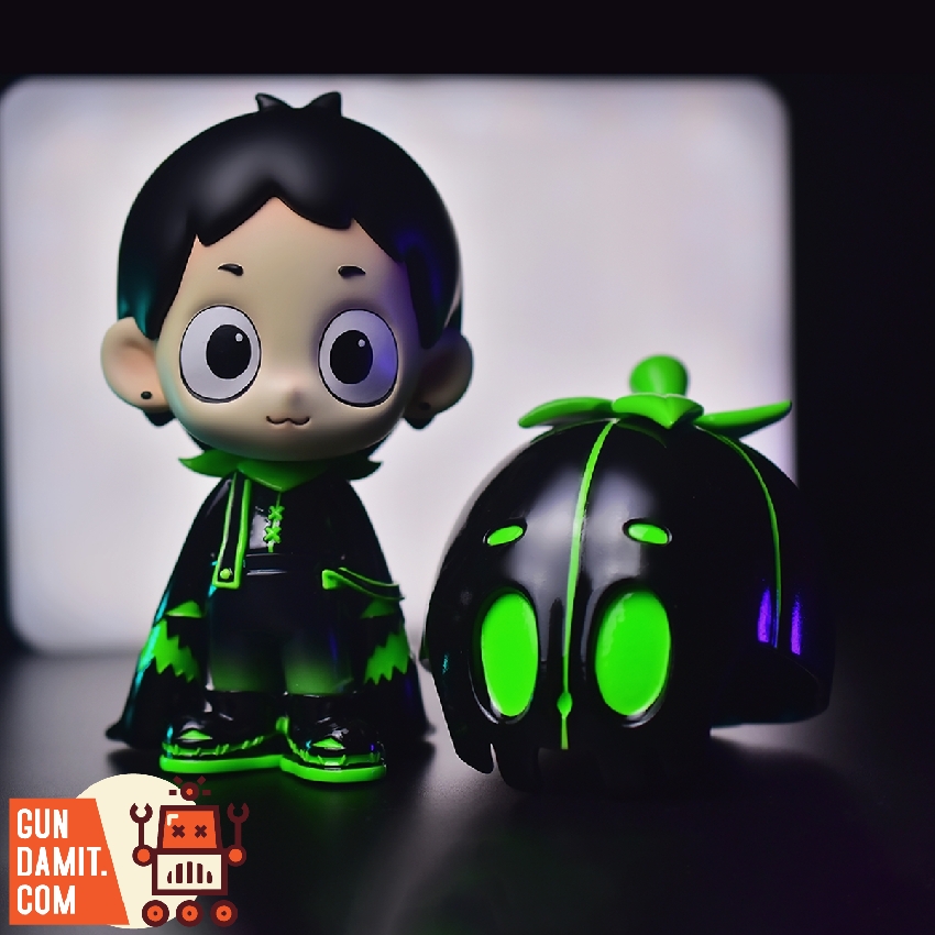 Luminous Dico figure standing next to detached glowing black and green pumpkin head accessory Luminous Dico figure standing next to detached glowing black and green pumpkin head accessory