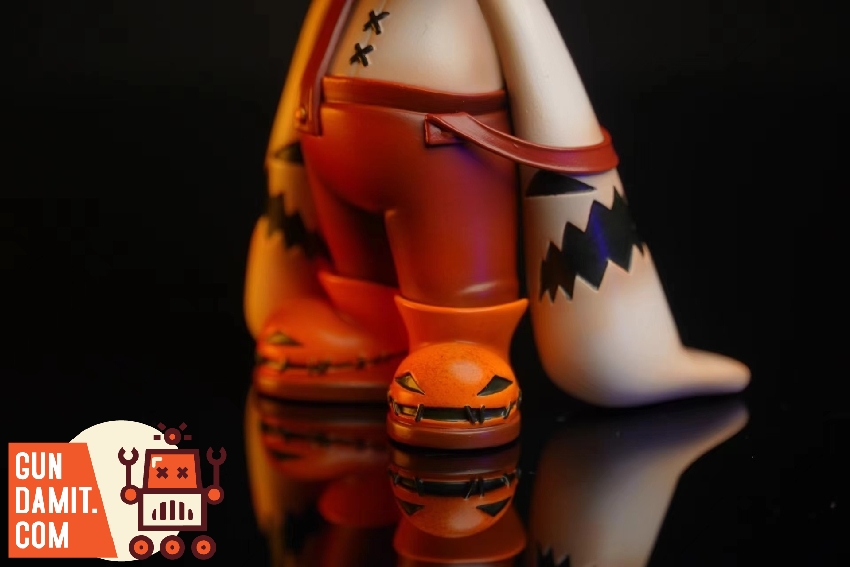 Dico original version feet close-up with small pumpkin companion figure on reflective surface Dico original version feet close-up with small pumpkin companion figure on reflective surface