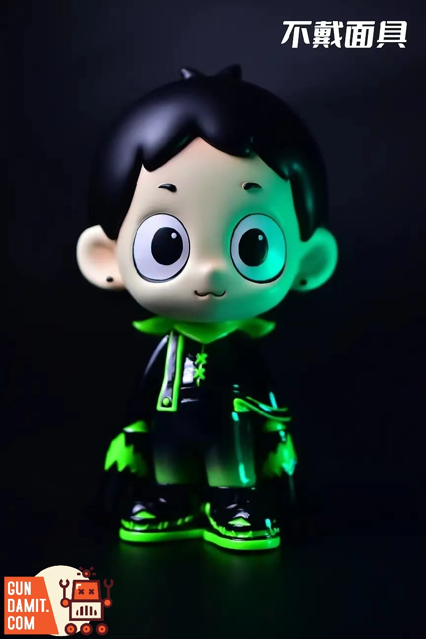Luminous Dico figure without mask showing big-eyed boy character with green glow accents Luminous Dico figure without mask showing big-eyed boy character with green glow accents