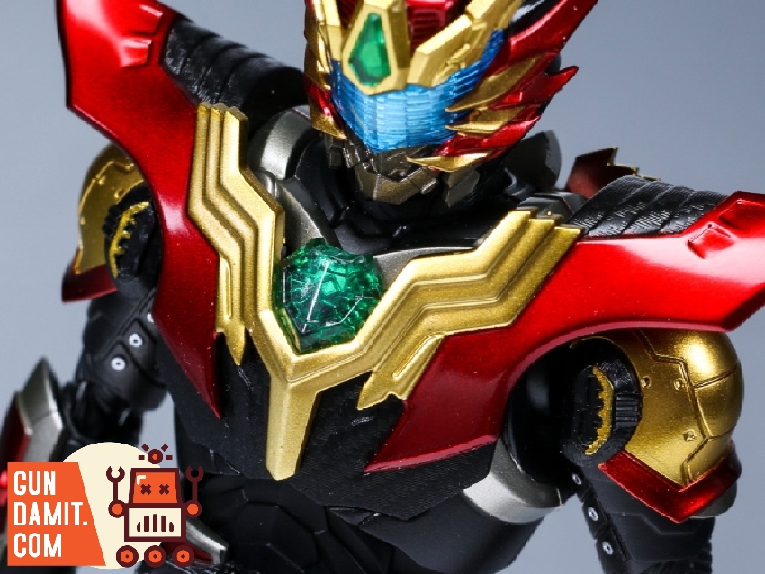 Armor Hero Carbon close-up of red and gold helmet with green gem detail Armor Hero Carbon close-up of red and gold helmet with green gem detail