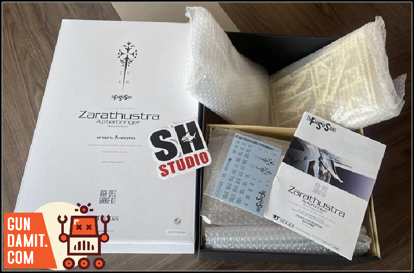 Garage kit packaging contents showing white box with resin parts bags and instruction materials Garage kit packaging contents showing white box with resin parts bags and instruction materials
