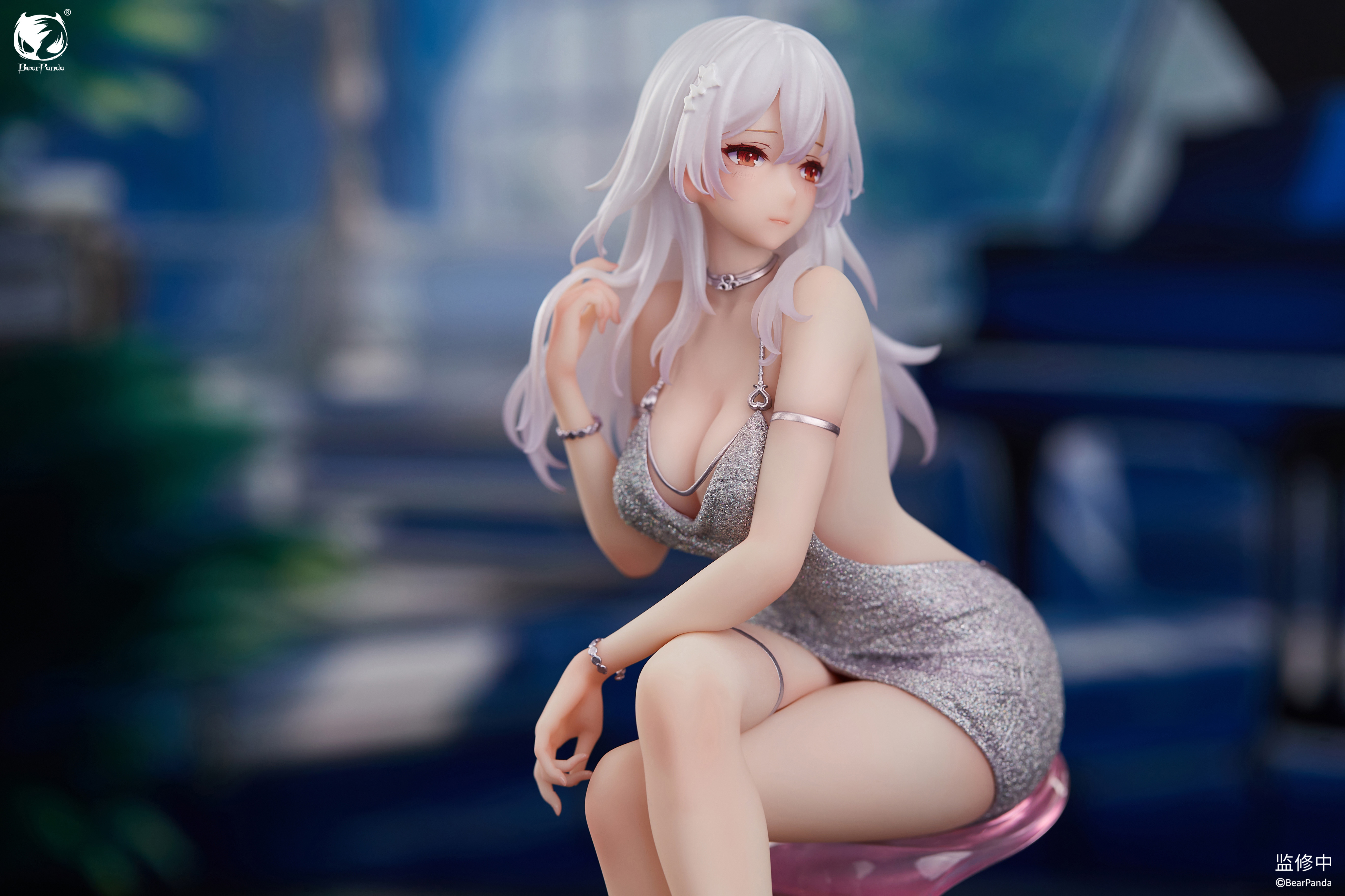 Front three-quarter view of Serina seated with crossed legs showing silver heels and arm bracelet details Front three-quarter view of Serina seated with crossed legs showing silver heels and arm bracelet details