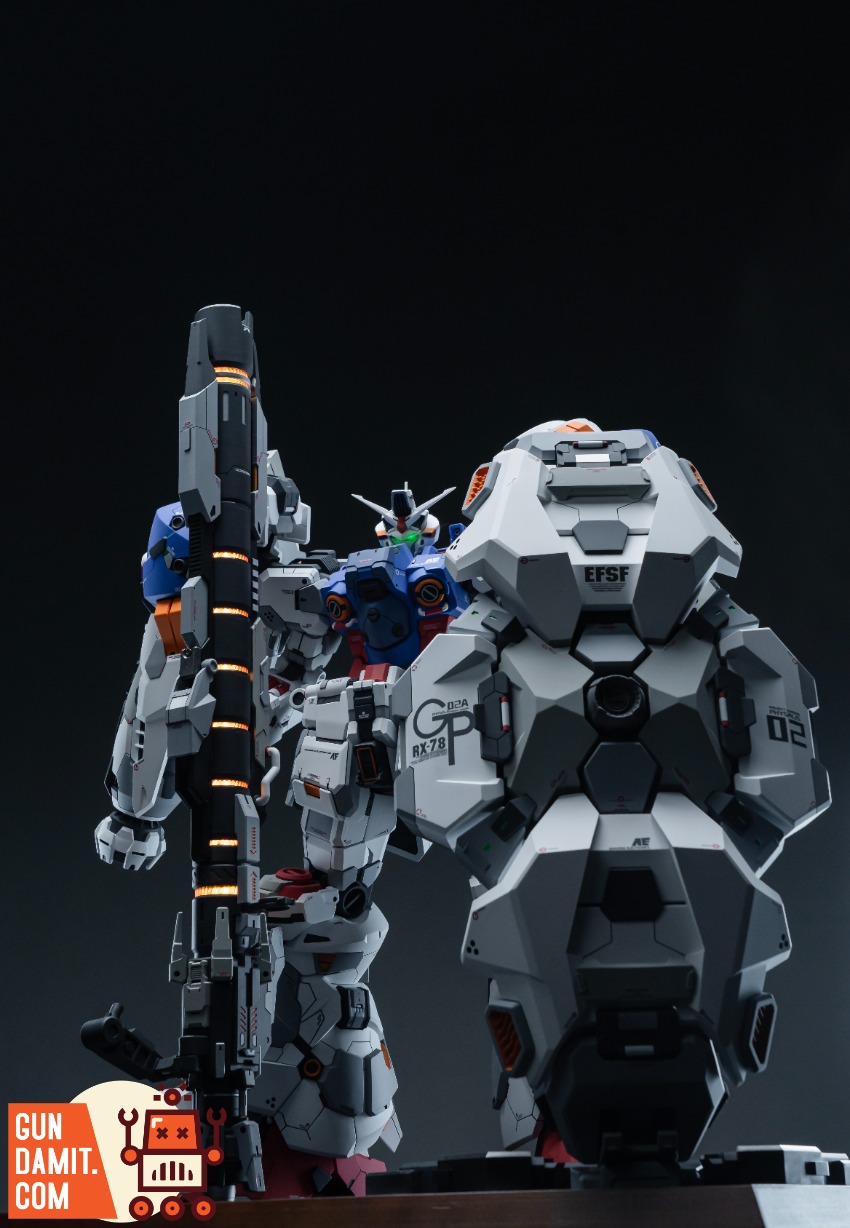 XXtoys Studio 1/48 Physalis Standard Version Two detailed Gundam models, one holding a large weapon, stand against a dark bac XXtoys Studio 1/48 Physalis Standard Version Two detailed Gundam models, one holding a large weapon, stand against a dark bac