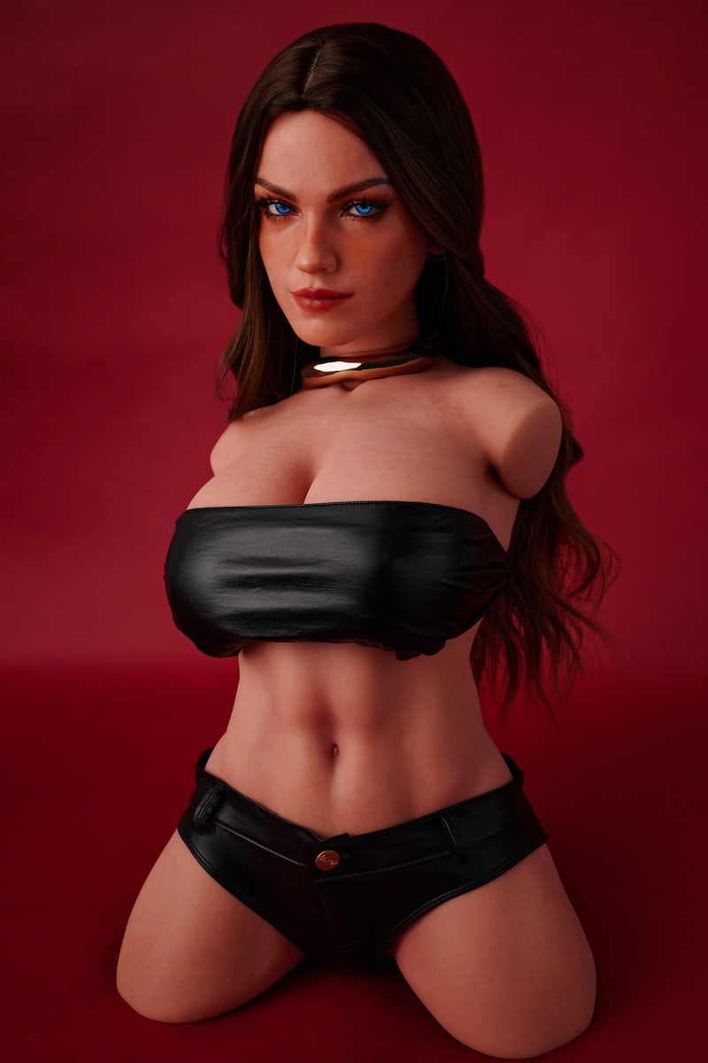 ULW 663# Emma: This front-view photo captures the doll's detailed torso featuring striking blue eyes and long wavy dark hair, wearing a black leather bandeau top that highlights her fair, smooth realistic skin and full curves against a red backdrop.