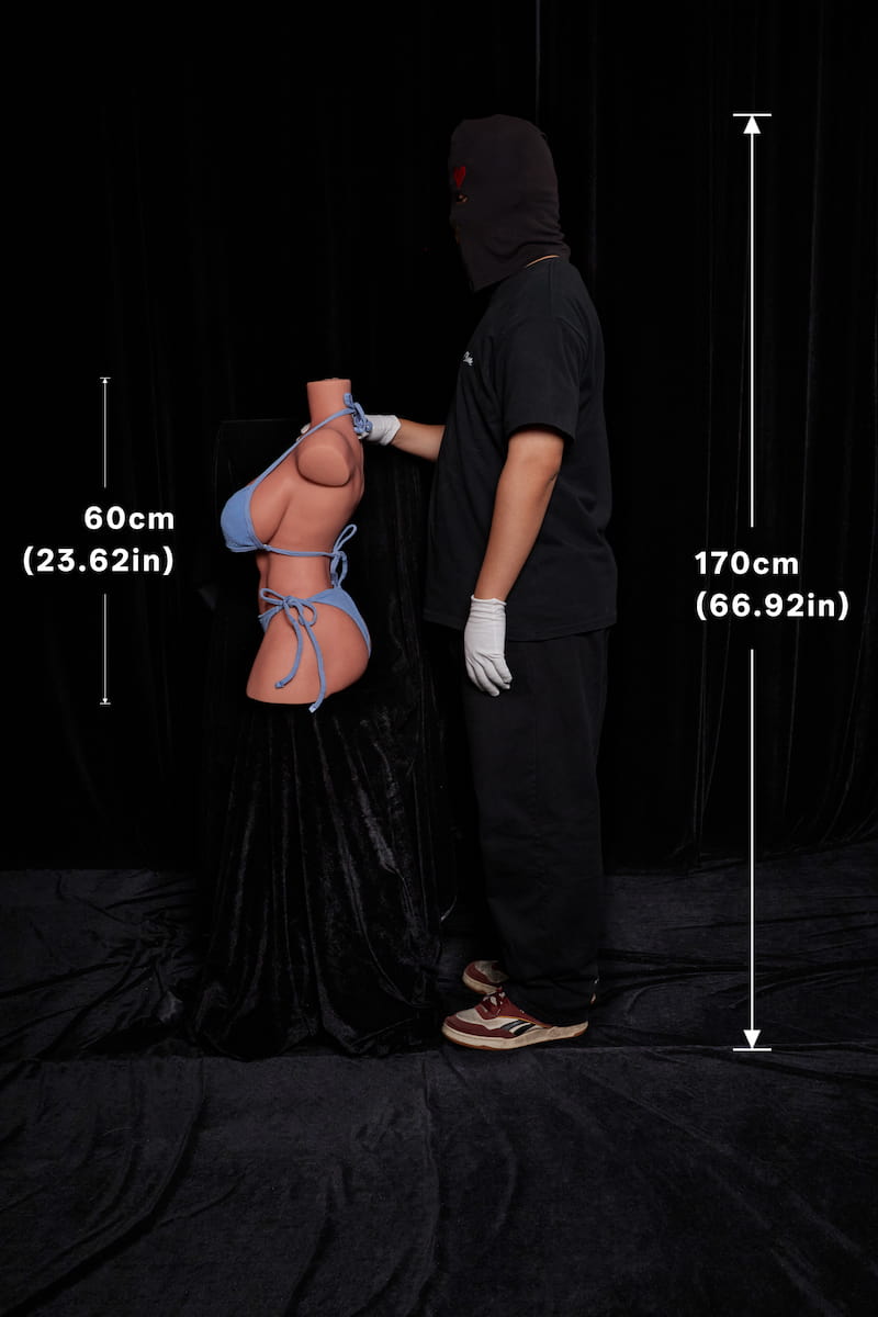 ULW 663# Emma: This pure side-profile view illustrates the scale between a 170cm tall man and the 60cm torso doll wearing a light blue bikini against a black backdrop, vividly presenting her prominent side-bust curve, curved hip line, and realistic skin texture.