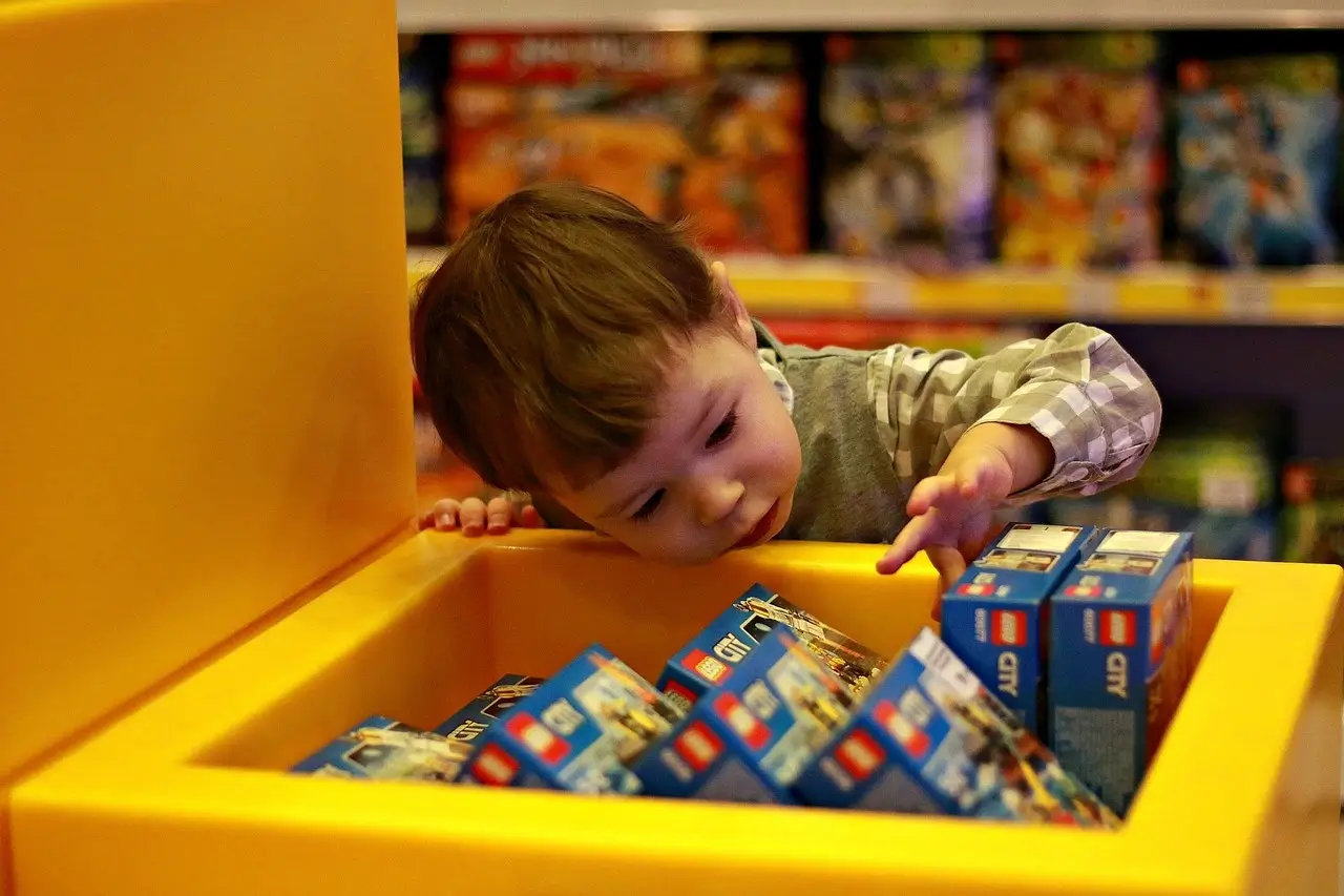 A child is carefully choosing a building block set in the store.