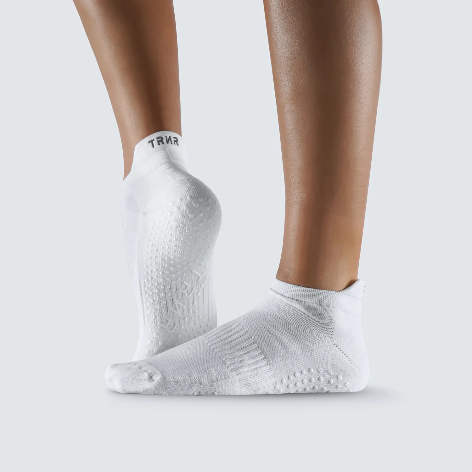 Ankle-length grip socks with silicone traction dots during indoor standing practice