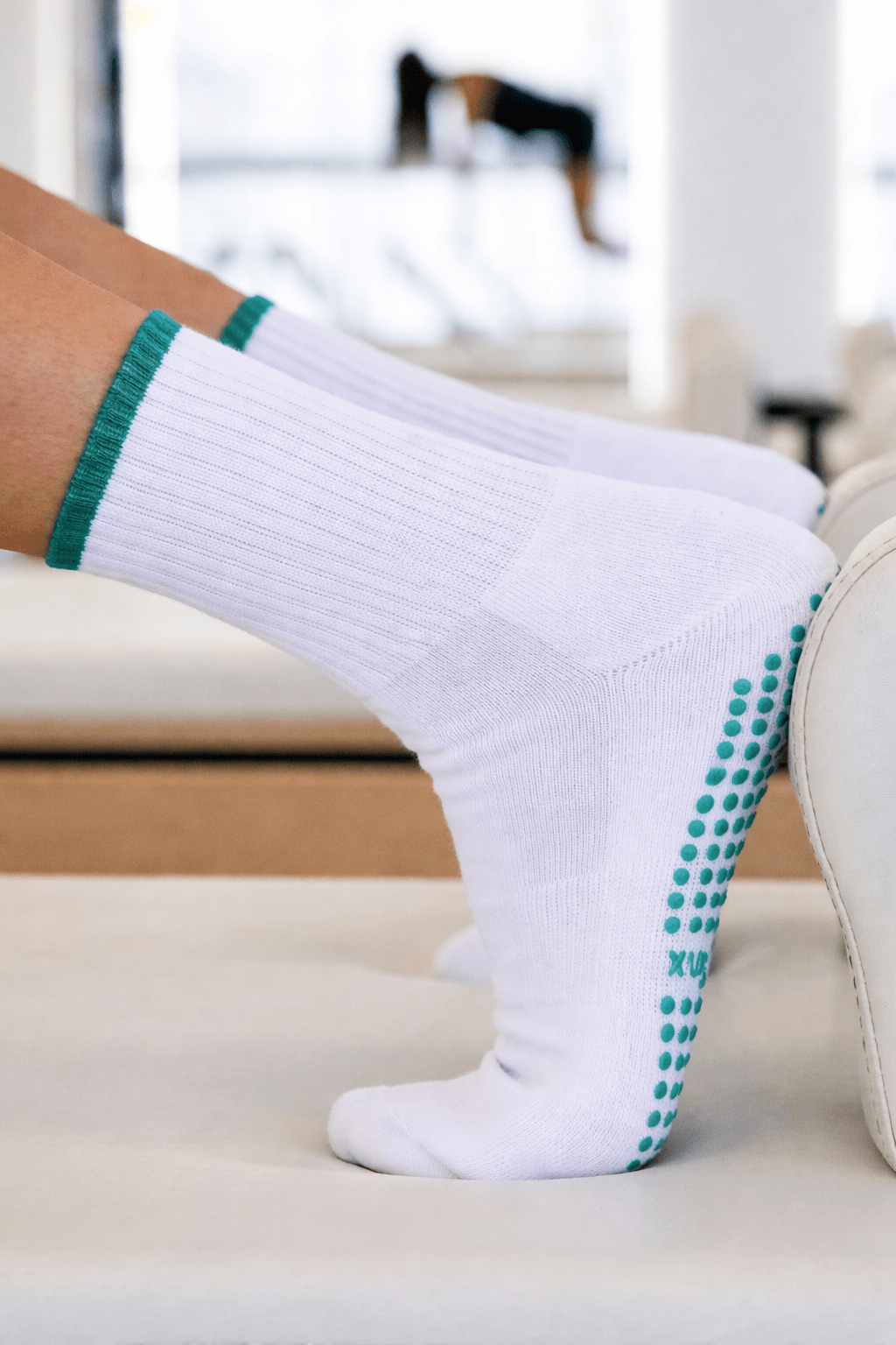 white grip socks with green anti-slip dots used in studio, manufactured by Grip Socks Factory China