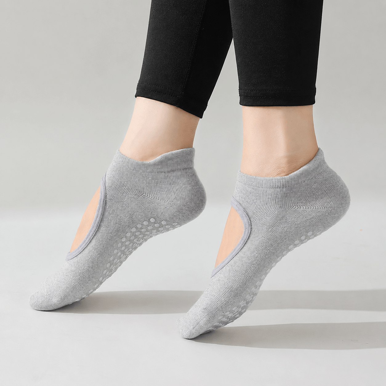 Custom branded yoga studio grip socks in grey color with non slip silicone dots, OEM yoga socks manufacturer and private label yoga socks supplier for wholesale pilates socks and yoga studio merchandise.