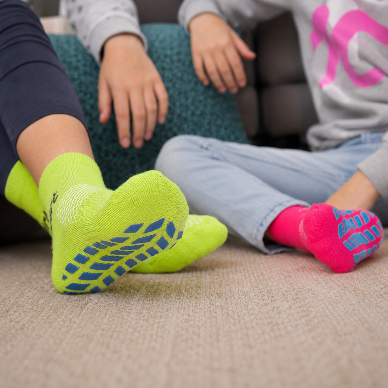 Kids wearing colorful trampoline park grip socks during indoor activities, custom trampoline socks from a professional trampoline socks supplier with anti-slip safety design.