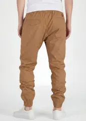 Rear close-up view of ItalyMorn men's tan brown jogger pants, showcasing the clean tailored seat, functional back pockets with flap detail, and secure ribbed ankle cuffs. Paired with white sneakers