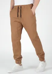 Angled front view of ItalyMorn men's brown jogger pants on a model with one hand in pocket. This highlights the smooth drape of the premium cotton-blend fabric and the versatile everyday fit