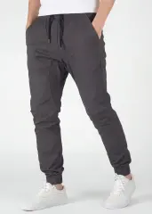 Angled front view of ItalyMorn men's olive grey jogger pants with hands in pockets, emphasizing the relaxed yet tailored fit and the smooth drape of the premium fabric