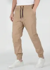 A detailed three-quarter front view of ItalyMorn men's khaki jogger pants, emphasizing the relaxed yet tailored fit and the smooth drape of the fabric. A model with hands in pockets against a plain background, wearing white sneakers.