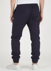 Back view of ItalyMorn men's navy blue jogger pants on a model, showing the clean tailored fit, functional back pockets, and snug ribbed ankle cuffs