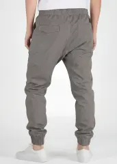 A rear view close-up of ItalyMorn men's mid grey jogger pants on a model, highlighting the functional back pockets, clean fit, and durable fabric texture. Paired with white sneakers